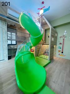 a green slide in a childs room at Wind Natural Parent-child Inn in Houli