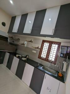 a kitchen with black and white counters and a sink at Jo's Homestay in Tiruvannāmalai
