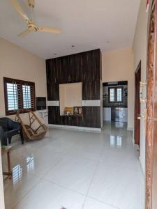 uma ampla sala de estar com piso em azulejo branco em Jo's Homestay em Tiruvannāmalai