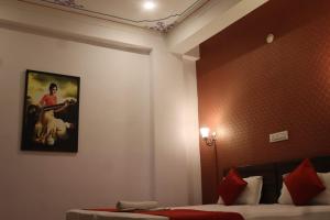 烏代浦的住宿－Hotel Shiv Palace，一间墙上挂着照片的带床的房间