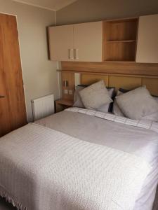 1 dormitorio con 1 cama blanca grande y 2 almohadas en Sunrise Holidays Skegness - Amethyst, en Skegness