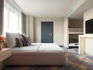ein Schlafzimmer mit einem Bett in einem Zimmer in der Unterkunft Science Hotel Prémium in Szeged
