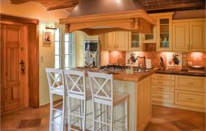 a kitchen with wooden cabinets and white stools at 5 Bedroom Pet Friendly Home In Srokowo in Srokowo