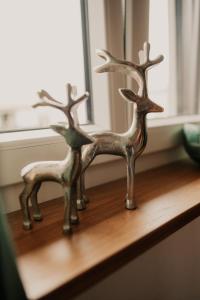 two metal deer statues sitting on a wooden shelf at Wohnung Finstermünz in Lenggries