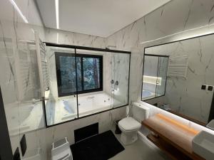 a bathroom with a tub and a toilet and a window at Pousada Encontro das Águas in Gonçalves