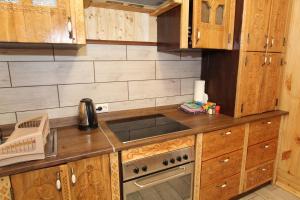 a kitchen with wooden cabinets and a stove top oven at Котедж "На Дачній" in Yaremche