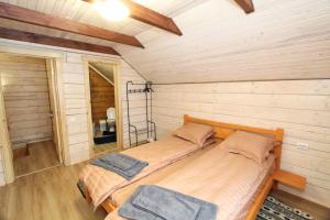 two beds in a room with wooden walls at Котедж "На Дачній" in Yaremche