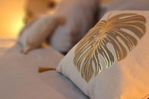 a pillow with a drawing of a palm tree on it at Gîte & Spa PRIVÉ "La Colline de Laveline" Proche GÉRARDMER in Laveline-du-Houx +68 photos