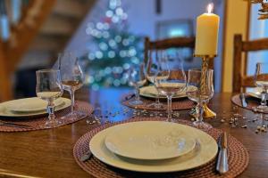a table with glasses and plates and a candle on it at Gîte & Spa PRIVÉ "La Colline de Laveline" Proche GÉRARDMER in Laveline-du-Houx
