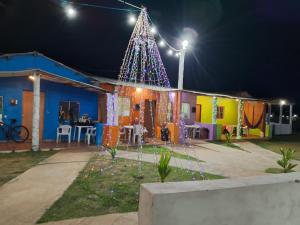 a christmas tree in front of a house at night at Villa D Mariscos in Paripueira