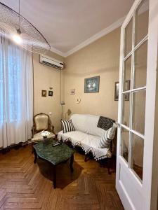 a living room with a couch and a table at Bright apartment in front of Vake Square in Tbilisi City