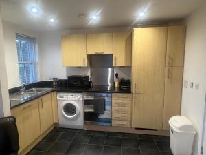 a kitchen with a washer and dryer in it at Broadway’s Canterbury City Escape in Canterbury