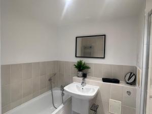 ein Badezimmer mit einem Waschbecken, einem WC und einem Spiegel in der Unterkunft Broadway’s Canterbury City Escape in Canterbury