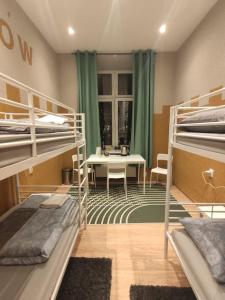 a room with three bunk beds and a table at Girls Hostel in Kraków