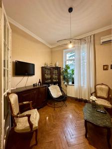 a living room with a television and a table and chairs at Bright apartment in front of Vake Square in Tbilisi City