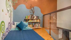 a bedroom with a blue bed with a book shelf at Casa Samai Boutique in Samaipata