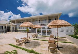 a building with chairs and umbrellas in front of it at Discovery Saipan Hotel in Garapan