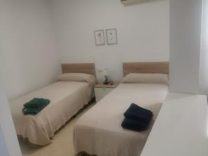 Dos camas en una habitación con almohadas azules. en Mérida Monumental y Vacacional, en Mérida
