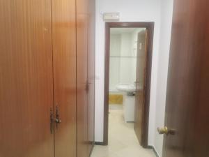a bathroom with a toilet and a sink and a door at Mérida Monumental y Vacacional in Merida