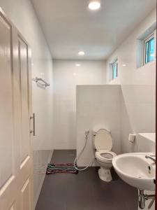 a bathroom with a toilet and a sink at เสริมสุขฟาร์มแอนด์โฮมสเตย์ จันทรบุรี in Tha Mai