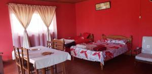 a bedroom with two beds and a table and a window at Antsaly in Antananarivo