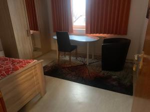 Zimmer mit einem Tisch, 2 Stühlen und einem Bett in der Unterkunft Monteure & Handwerker einfach, unkompliziert und preiswert in Alsfeld in Alsfeld
