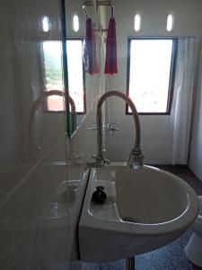 ein Bad mit einem Waschbecken und einer Dusche in der Unterkunft Toraja Sanggalangi Homestay in Rantepao