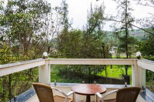 a table and two chairs on a balcony with a view at Hangout Villas in Lonavala