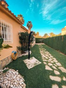 a garden with a stone pathway in front of a house at Impresionante villa con piscina in Oliva