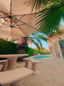 a patio with a table and an umbrella and a pool at Impresionante villa con piscina in Oliva