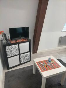 calvaire studio chaleureux tout équipé في سودون: غرفة معيشة مع تلفزيون وطاولة
