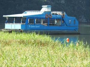 a blue boat sitting in the water on a river at The Pont Home Owners in Port Edward