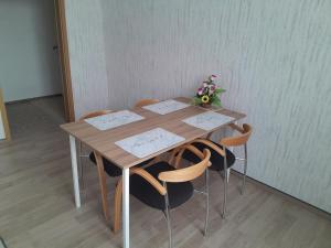a wooden table with chairs and a vase of flowers at Ferienwohnung Mantei in Altentreptow