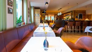 a row of tables in a restaurant with chairs at Hotel-Restaurant Ruland in Altenahr