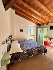 a bedroom with a bed and a wooden ceiling at B&B Convivium in Stazzema