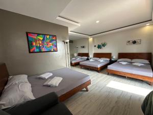 Zimmer mit 3 Betten und Wandgemälde in der Unterkunft D Villa Nueva's Beach House in Lobo