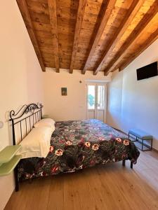 a bed in a room with a wooden ceiling at B&B Convivium in Stazzema