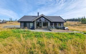 a house in a field with a large window at Lovely Home In Lillehammer With Kitchen in Lillehammer +31 photos