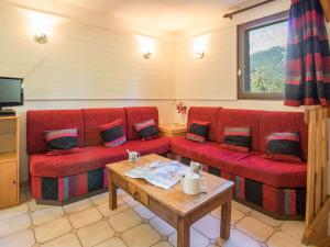 - un salon avec deux canapés rouges et une table dans l'établissement Appartement Le Monêtier-les-Bains, 5 pièces, 10 personnes - FR-1-330F-144, au Monêtier-les-Bains