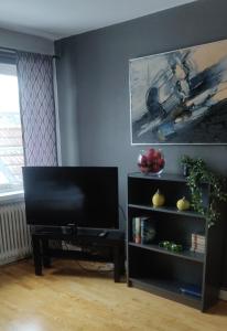 a living room with a flat screen tv and a table at Åberg12 in Höör