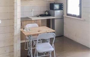 una piccola cucina con tavolo in legno e sedie bianche di Gorgeous Home In Rybical With Kitchen a Ryn