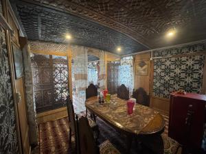 een eetkamer met een tafel in een kamer met behang bij HERITAGE CASTLE GROUP OF HOUSEBOAT in Srinagar
