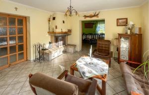 un soggiorno con tavolo e camino di 4 Bedroom Cozy Home In Lidzbark Warminski a Lidzbark Warmiński