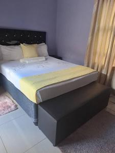 1 dormitorio con 1 cama con cabecero negro en Virgin guesthouse en Francistown