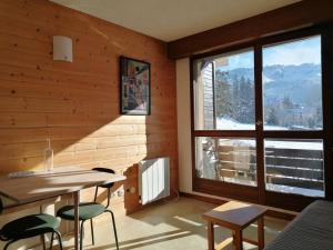 Habitación con mesa, sillas y ventana grande. en Studio Villard-de-Lans, 1 pièce, 4 personnes - FR-1-548-41, en Villard-de-Lans