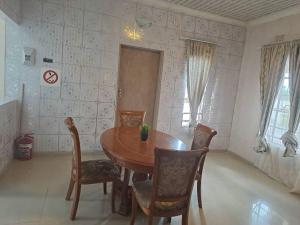 comedor con mesa de madera y sillas en Virgin guesthouse en Francistown