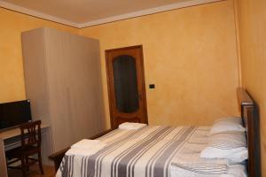 Dormitorio con cama, escritorio y TV en Sant'Anna, en Saluzzo