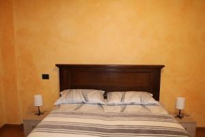 a bed with two white pillows and two lamps at Sant'Anna in Saluzzo