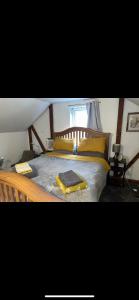 a bedroom with a wooden bed with yellow pillows at I bedroom flat on a gated farm in Tadworth in Purley