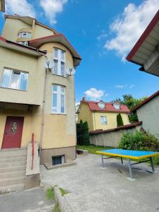 a blue ping pong table in front of a house at Hostel Serge in Lviv